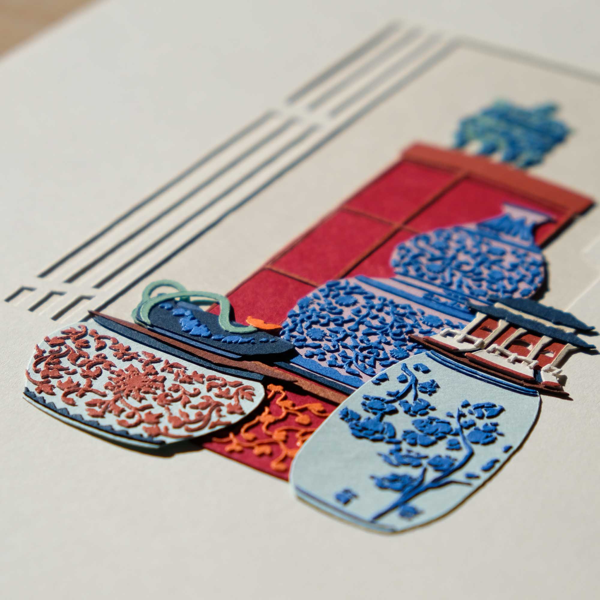 An angled view of the artwork under bright sunlight captures the dimensionality of the cut-out floral motifs. The tiny ornamentation covers most of the vessels.