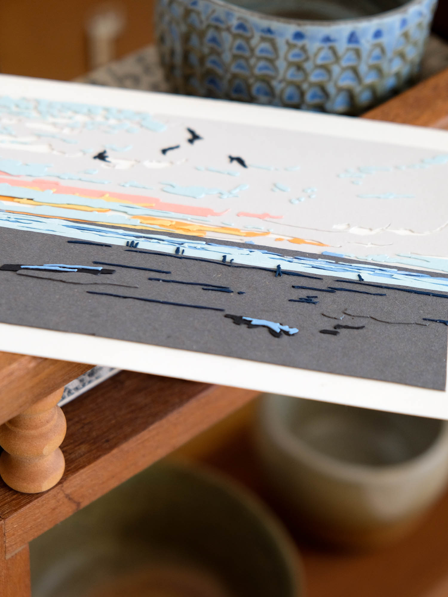 A closer view of the paper birds reveals small winged silhouettes against little drifts of clouds.